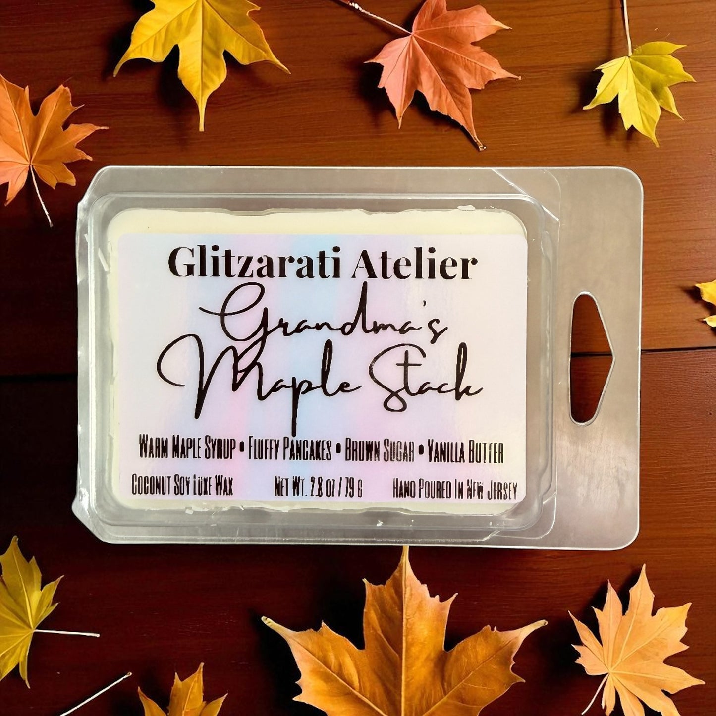 Packaged product with 'Glitzerati Atelier' branding on a wooden surface with autumn leaves.