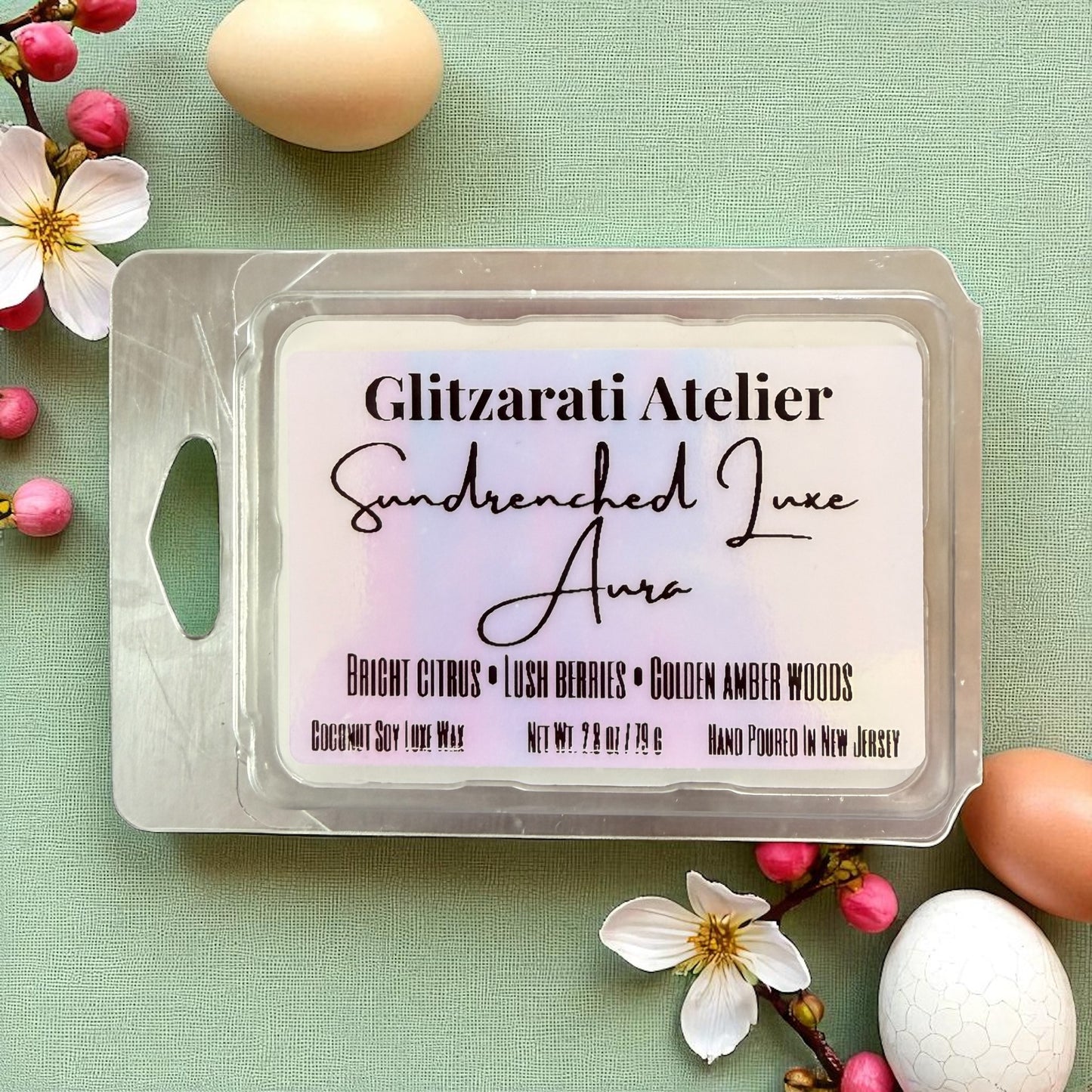 Wax melt packaging with 'Glitzarati Atelier' branding on a green background with flowers and eggs.