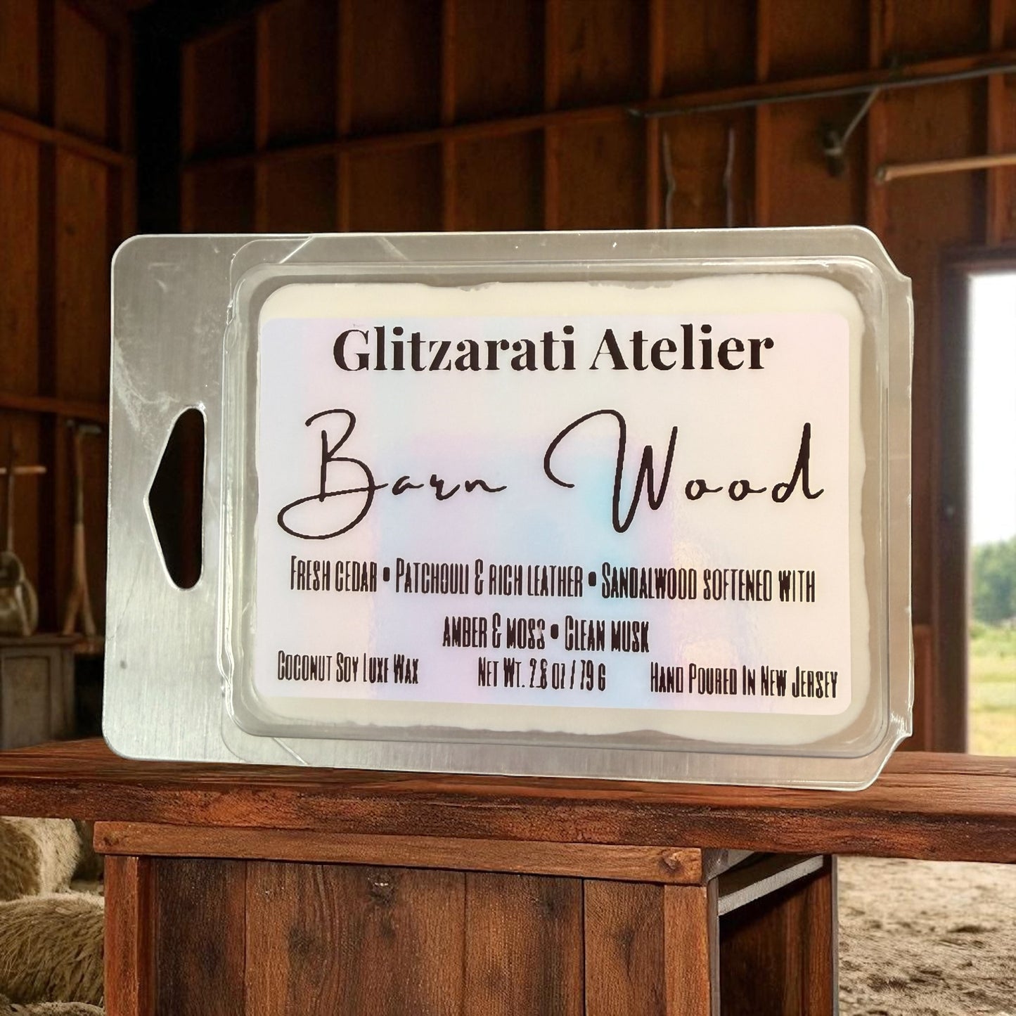 Wax melt packaging with 'Glitzarati Atelier Barn Wood' label on a wooden surface.
