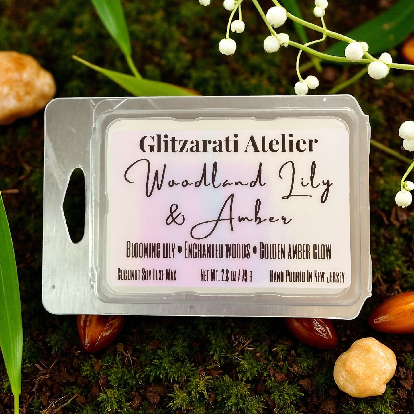 Wax melt packaging labeled 'Woodland Lily & Amber' by Glitzarati Atelier on a natural background.