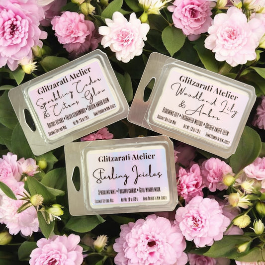 Three scented wax melts with labels on a bed of pink flowers