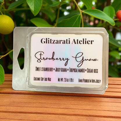 Wax melt packaging with 'Glitzerati Atelier' branding on a wooden surface with greenery in the background.
